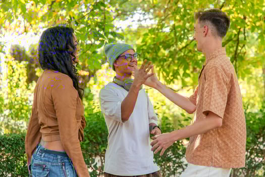 Young multicultural friends laughing and having fun together in a park photo
