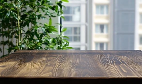 Wood table top with green plant background for product mockups and interior design photo