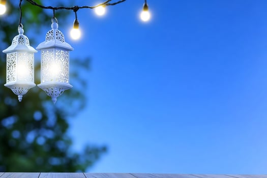 Decorative lanterns and string lights against a blue evening sky background photo