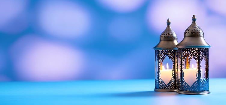 Ornate lanterns with candlelight against soft blue backdrop photo