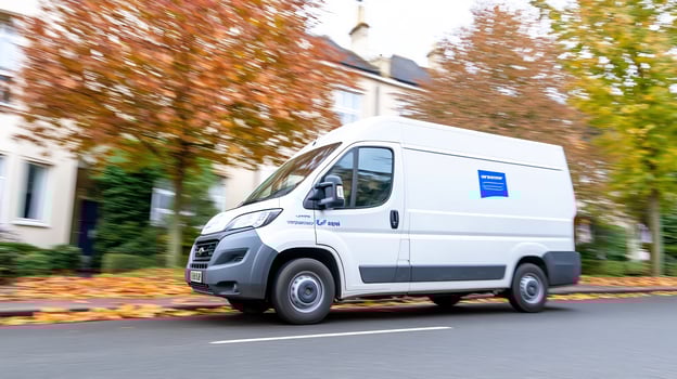 Delivery van driving on road in autumn season photo
