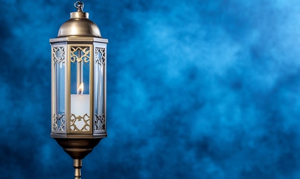 Decorative bronze candle lamp against blue textured background photo