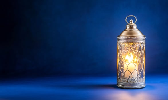 Illuminated decorative lantern with candle light against gradient blue background photo
