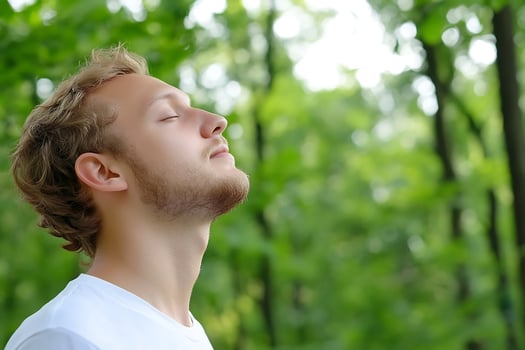 Man breathing deeply outdoors experiencing relaxation and wellness in nature photo