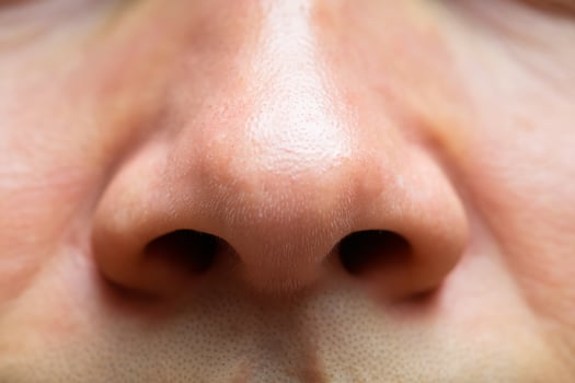 Close-up of a man's nose showcasing skin texture and fine details. photo
