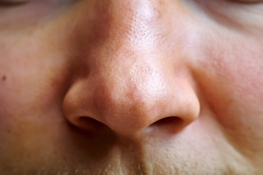 Close-up of a male's nose, showcasing fine details and texture on a light skin tone. photo