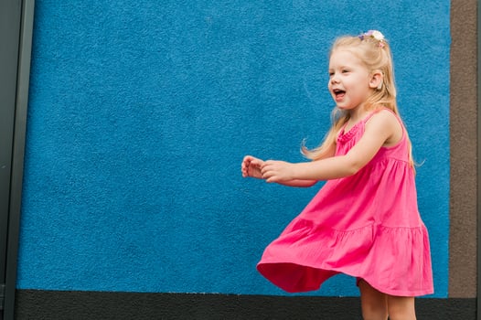 Child with hearing problem and cochlear implant dance in street, deaf kid began to hear. Hearing loss in childhood and treatment concept. Inclusion and people with disability. Copy space photo