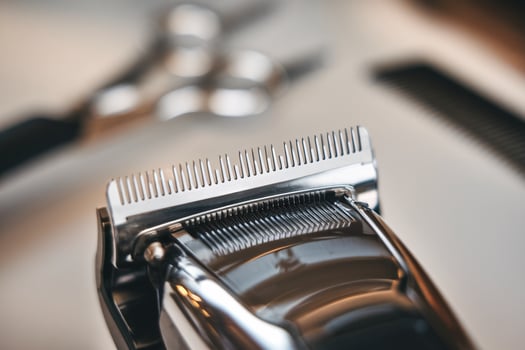 Close-up of a professional hair clipper with a comb attachment on a barber's workstation. photo