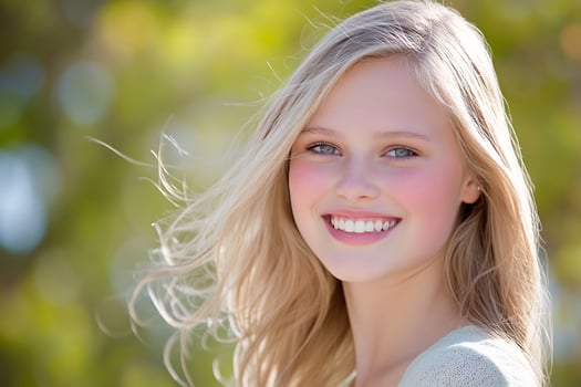 Portrait of smiling blonde woman in natural light outdoors photo
