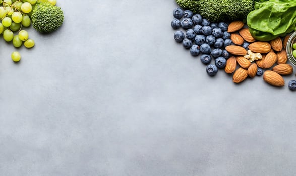 Healthy food arrangement with fruits vegetables and nuts overhead flat lay photo
