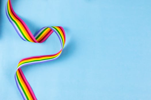 LGBTQ Rainbow Ribbon on Bright Blue Background photo