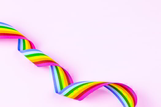 LGBTQ Rainbow Ribbon on Bright Pink Background photo