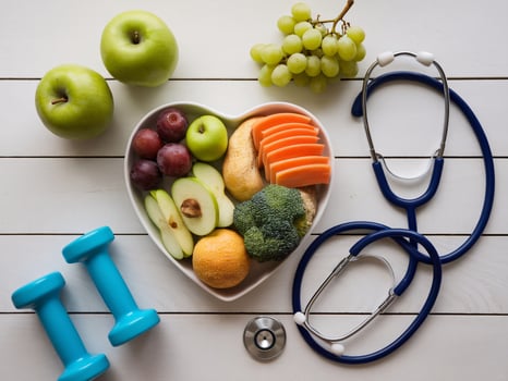 Healthy lifestyle concept featuring a heart-shaped bowl with fresh fruits and vegetables. photo