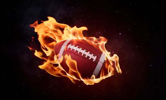 A dynamic football engulfed in flames against a dark background, showcasing intense energy and excitement. photo