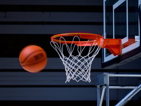 A basketball flies towards the hoop, showcasing thrilling action in a gym environment. photo