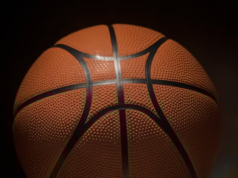 Close-up of a textured basketball against a dark background, emphasizing its detail and design. photo