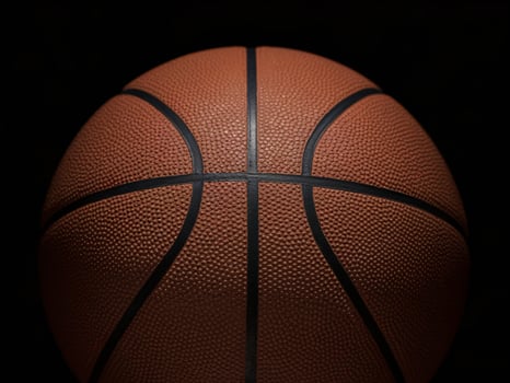 Close-up of a textured basketball against a dark background, showcasing its details and shape. photo