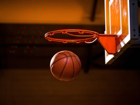 A basketball is about to enter the hoop, showcasing a dynamic moment in a game. photo