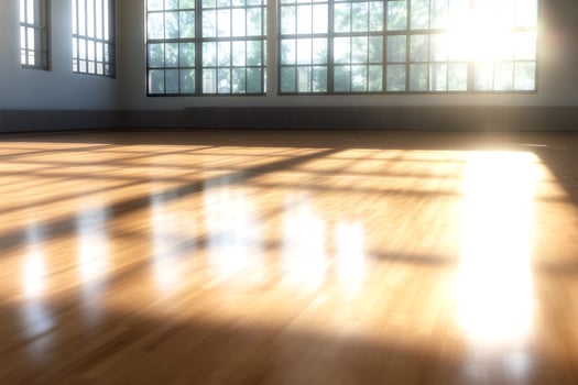 Sunlit empty room with wooden floor and large windows photo