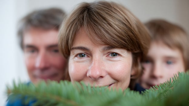 Family peek through verdant fir branches, Caucasian expressions of Yuletide wonder and Pagan evergreen reverie, Celtic Christmas cheer illuminates photo