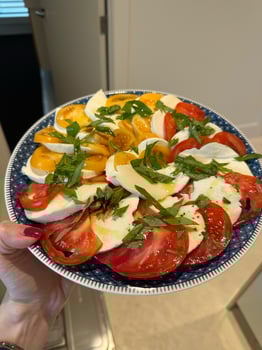 Colorful Caprese salad featuring fresh tomatoes, mozzarella slices, basil leaves, and olive oil on a decorative plate, showcasing vibrant flavors and culinary elegance, concept of healthy dining photo