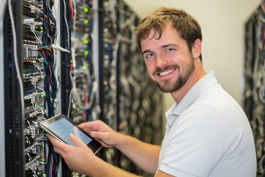 Server room technician with tablet inspecting data racks and network cables photo