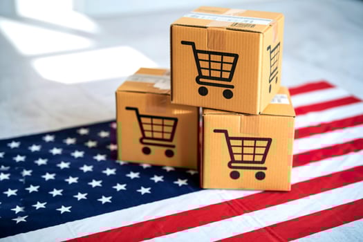 Cardboard boxes with shopping cart icons stacked on american flag photo