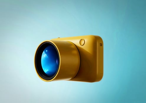 Bright yellow digital camera with reflective lens against a gradient blue background photo