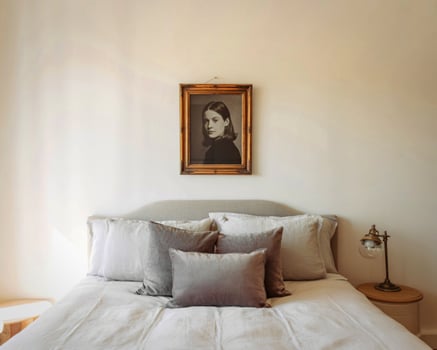Cozy bedroom with vintage portrait above a plush bed photo
