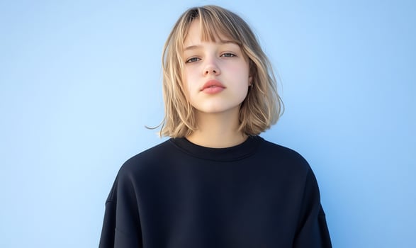 Young woman portrait against light blue background minimalist style photo