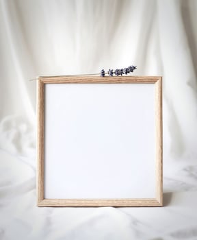Minimalist wooden frame with lavender sprig on soft white fabric background photo