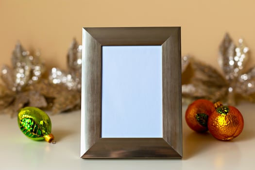 Mockup. Christmas. Silver photo frame stands prominently with blank space, surrounded by vibrant ornaments and shimmering decorations, creating warm and inviting atmosphere for holiday memories