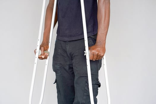 Black man with crutch. Close-up photo