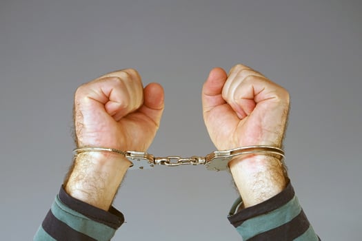 Criminal hands of man locked in handcuffs photo