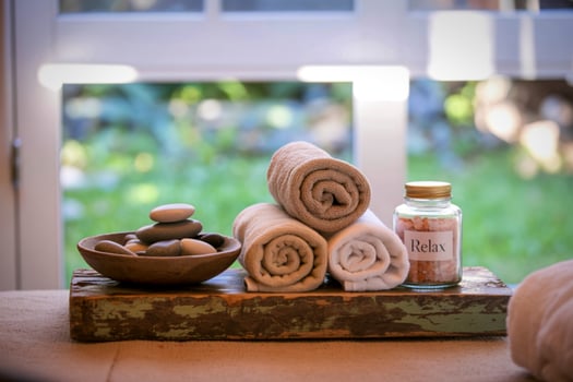 Relaxing spa scene with rolled towels and smooth stones photo