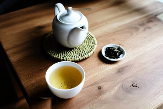 A serene tea ceremony with a white teapot and cup on a wooden table photo