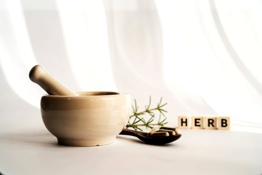 Mortar and pestle with herbal capsules and the word herb spelled out photo