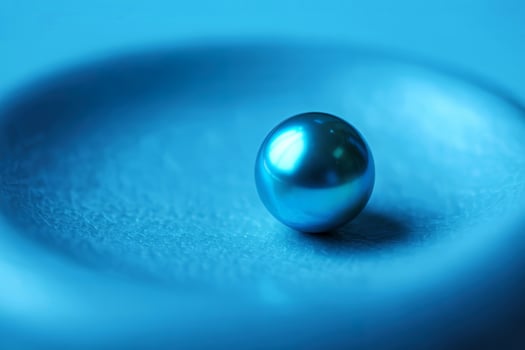 A blue pearl on top of a blue surface photo