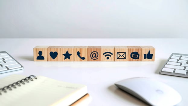 Wooden blocks with social media icons and communication symbols on a desk photo