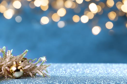 Festive golden ornament and bokeh lights on sparkling surface photo