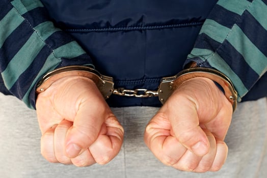 Hands locked in handcuffs. Close-up view photo