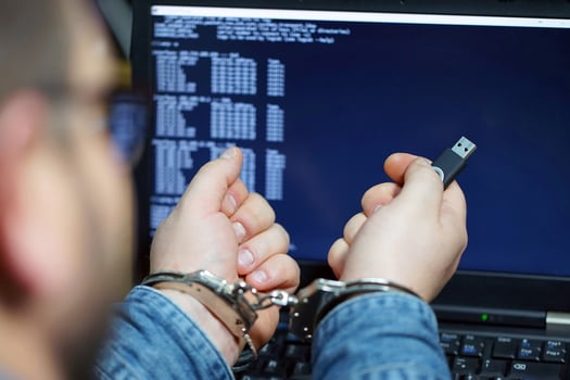 Criminal hacker hands locked in handcuffs photo