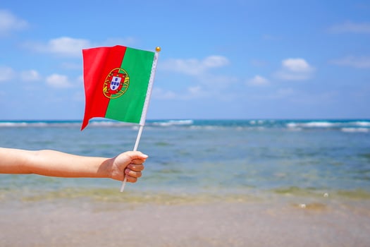 Little girl hands hold Portugal flag against the sea horizon. photo