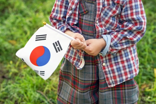 Little boy hands hold South Korea flag photo