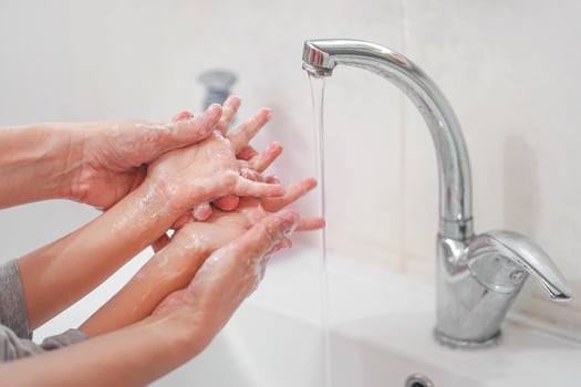 Closeup of a woman washing the hands of a child carefully with soap. The concept of cleanliness and health and the fight against the virus. photo