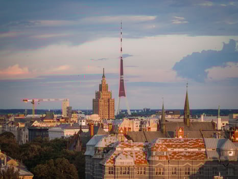 Riga, Latvia skyline at sunset with the Riga TV Tower, Jugendstil rooftops, spires, and the Latvian Academy of Sciences building in view. photo