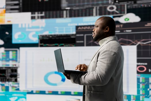 African american businessman in a digital environment focused on graphs, working on strategic planning analysis for profitability and performance. Insightfulness and fintech forecasting. photo