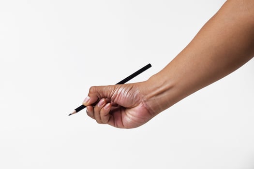 Detail of Asian mans hand holding black pencil on white background photo