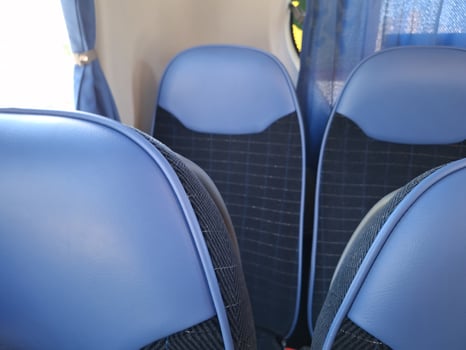 Empty blue bus seats with blue curtains in passenger vehicle interior photo