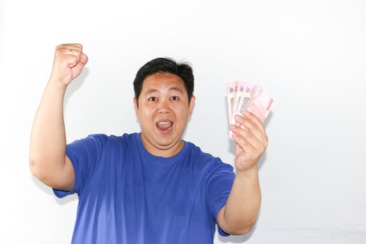 Asian man holding up money and showing his fist photo